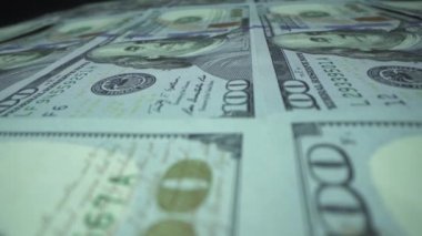 100 dolarlık banknotlar makroyu basıyor. Enflasyon ve deflasyon kavramı. Para makinesi. Para döngüsü oluşturuluyor. Benjamin Franklin banknotları basan makine. Masada güçlü Amerikan parası var..