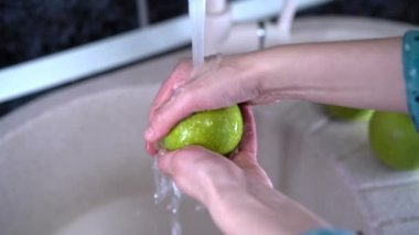 Taşıyıcı banttaki yeşil elmalar, organik meyve suyunu sıkmak için otomasyon. Soğuk sıkılmış meyve suyu şişeleme fabrikası. Meyve ambalajı depolama gıda işleme tesisi.