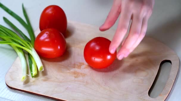 Жінки використовують кухонний ніж для різання свіжих помідорів на дерев'яній обробній дошці. Здорове харчування. Нарізаний помідор . — стокове відео