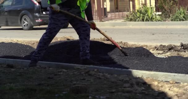 New York, USA - MAY 29 2021: Man pours asphalt concrete mixture for road repair — Stockvideo