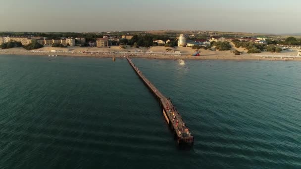 Florida, USA - 31 mei 2021: Vlieg terug vanuit de lucht van het silhouet van een vissteiger op de oceaan met een kleurrijke en gouden zonsondergang. Napels Beach en Fishing Pier bij Sunset, Florida. Drone vliegt terug. — Stockvideo