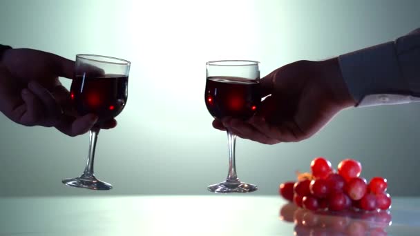 Yakın planda iki kişi beyaz arka planda kırmızı şaraplı kadehlerle tezahürat yapıyor. — Stok video