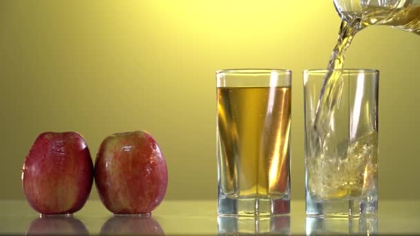 ガラスとリンゴの健康的なリンゴジュース。ジューススプラッシュスローモーション映像。表を参照。眼鏡が２つ。新鮮な飲み物だ。夏のコンセプト. — ストック動画