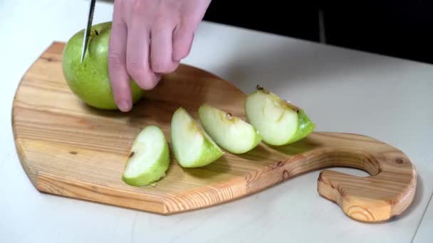 Cutting green juicy apple on wooden table in the kitchen, healthy nutrition, fruit diet — Stockvideo