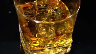 Buz, viski bardağına çok yavaş bir şekilde düştü. Macro Laowa 'nın yüksek hızlı sinema kamerası ile çektiği çekim.