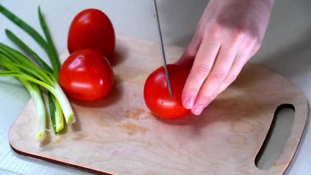 Couper la tomate rouge dans la lumière du matin. Couper les légumes frais pour la cuisson à la lumière du matin. Macro. Tomate coupant tout près. Lumière naturelle du soleil. — Video