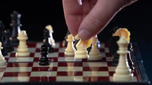 Gros plan de l'homme jouant aux échecs et faisant mouvement avec une tour blanche isolée sur fond noir. Homme d'affaires faisant un mouvement stratégique dans le jeu d'échecs. hobby intellectuel, concept de stratégie — Video