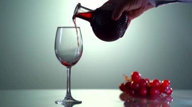 Şarap kadehine dökülen kırmızı şarap, yakın plan.