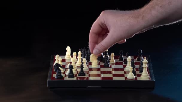 Hand självsäker affärsman använda biskop schackpjäs vit spela schack spel. Grandmaster gör flytten isolerad på svart bakgrund. Affärsstrategi för vinst och framgång koncept — Stockvideo