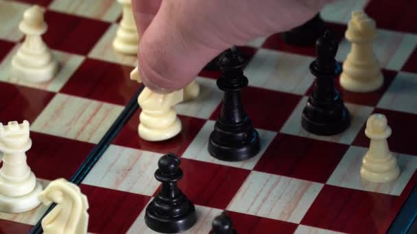 Sakkozás - egy férfi kéz mozgó fehér sakk lovag egy hagyományos fa sakktáblán. 4k — Stock videók