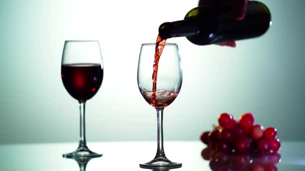 Супер повільний рух заливання червоного вина з пляшки в чашку. Знімок на високошвидкісній кінокамері 4K роздільної здатності . — стокове відео