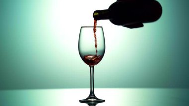 - Şarap. Kırmızı şarap koyu arkaplandan şarap bardağına dökülüyor. Şişeden gül şarabı dökülüyor. Ağır çekim. 4k