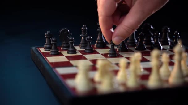 Hand självsäker affärsman använda biskop schackpjäs vit spela schack spel. Grandmaster gör flytten isolerad på svart bakgrund. Affärsstrategi för vinst och framgång koncept. — Stockvideo