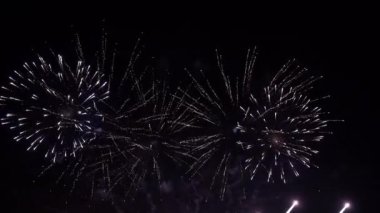 4K gerçek havai fişek arka planı. Gece gökyüzünde bokeh ışıkları olan gerçek altın sarısı havai fişeklerin soyut bulanıklığı. Parlak havai fişek gösterisi. Yeni yıl arifesi havai fişek kutlaması