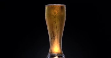 Su damlalı bir bardakta soğuk light bira. Alkol konsepti. Craft Birası yakın çekim. Döndürme 360 derece. 4K UHD video 3840x2160
