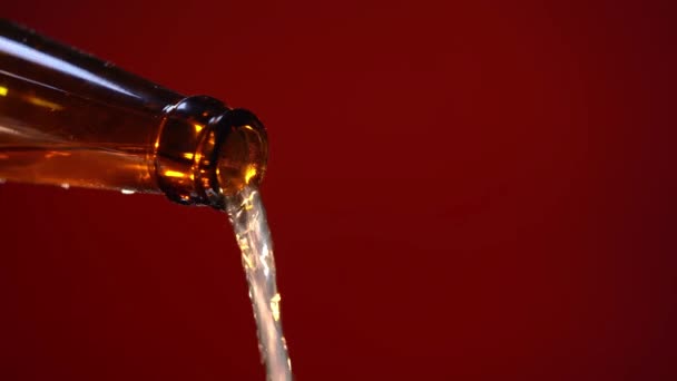 Woda przelewająca się z butelki do szklanki, izolowana na czerwono — Wideo stockowe