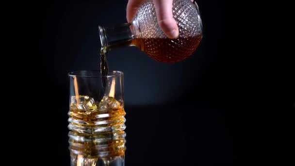 Whisky dorato in vetro sfaccettato con cubetti di ghiaccio ruotanti su macro di sfondo nero. Bevande alcoliche, cocktail, alcol. 4k — Video Stock