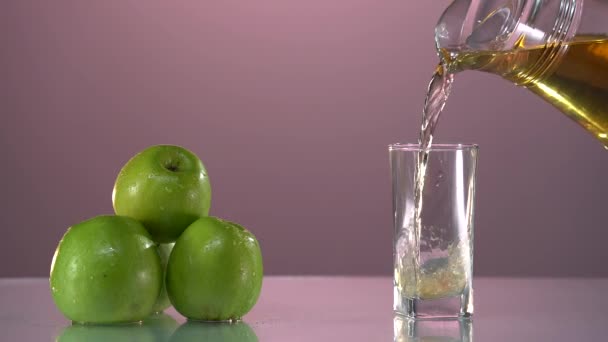 Taze elma suyunu bardağa, yeşil elmaları da siyah arka plana dökmeye devam edin. Ağır çekim. Sağlıklı yiyecek, vitamin, meyve. — Stok video