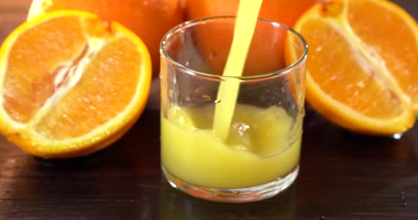 Orangensaft aus Glas in Glas gießen. Schließen Sie ein Glas frischen Orangensaft. Zubereitung eines gesunden Frühstücks aus natürlichen Zutaten. Hausgemachter Fruchtsaft auf dem Tisch. Bio-Vitamingetränk — Stockvideo