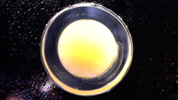 Extreme close-up beer bubbles in a glass while being poured. Foam sliding down side of beer glass. Close up of a beer swirling in a pint glass as its being poured — Stock Video