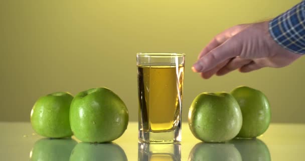 Grand verre de jus d'orange fraîchement pressé debout sur une table de pique-nique en bois en plein air par une chaude journée d'été avec une orange fraîche coupée en deux — Video