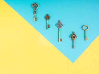 Mavi ve sarı arkaplanda mavi arkaplan açılı beş bronz antika anahtar.