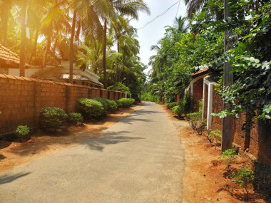 Kırsal kesimde asfalt yol kırmızı tuğla çitlerle çevrili. Seyahat kavramı