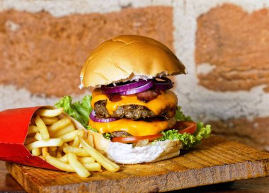 Pastırmalı, sarı peynirli, domatesli, yeşil salatalı, marullu ve kırmızı soğanlı nefis el yapımı hamburger.