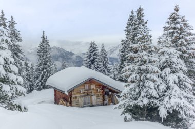 Issız bir dağ evi ve İsviçre Alpleri 'nin yukarısında Davos yakınlarında taze toz karla kaplı köyler.