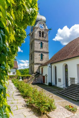 İsviçre 'nin ortaçağ kasabası Eglisau' daki kilisenin duvarı ve bahçesi. Güneşli ve ılık bir bahar gününde arka planda çan kulesi var.