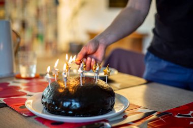 Annem doğum günü pastasında mum yakıyor.
