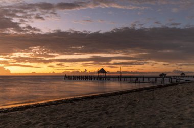 Cancun, Meksika sahilindeki ahşap bir iskelede çarpıcı ve renkli bir gün doğumu..
