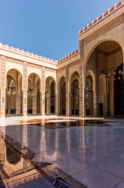 Bahreyn 'deki El Fetih Büyük Camii' nin Güneş Işıklı Kemerleri ve Dekoratif İslami Kaligrafi.