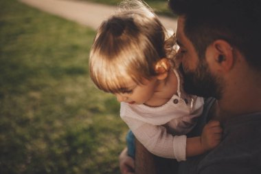 Sevgi dolu bir baba çocuğuna dikkatlice sarılır..
