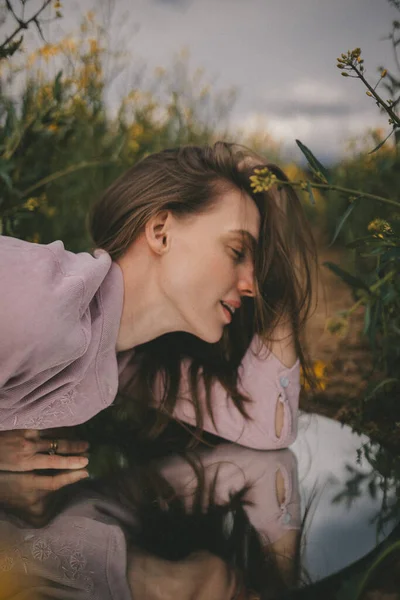 Kolza tarlasında güzel bir kadının yansıması..