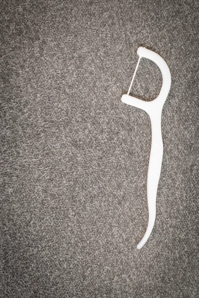 Perangkat Oral: benang gigi putih pada latar belakang kain — Stok Foto