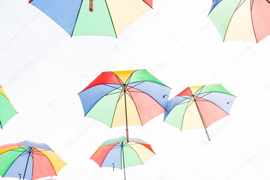 Rainbow umbrella on sky background