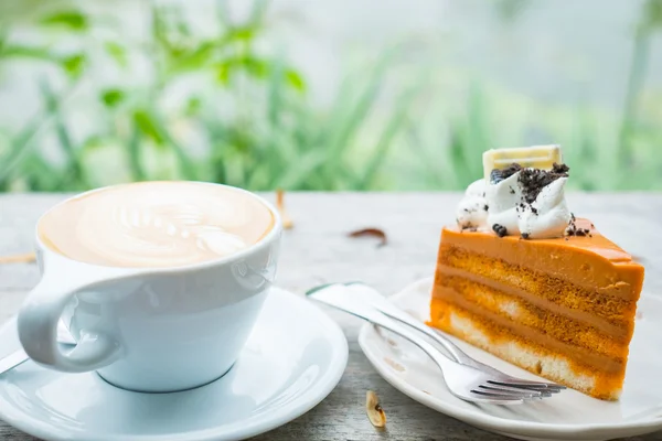 Latte caliente y pastel de té tailandés en escritorio de madera —  Fotos de Stock