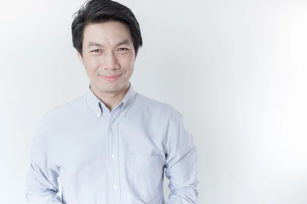 Jovem homem asiático sorrindo no fundo branco — Fotografia de Stock