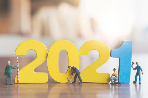 Miniature people : Worker team build wooden number 2021  , Happy new year concept