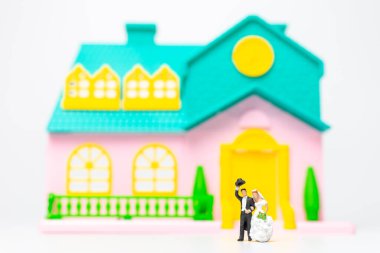 Minyatür insanlar, evlerinin önünde yan yana duran çift, sevgililer günü konsepti.