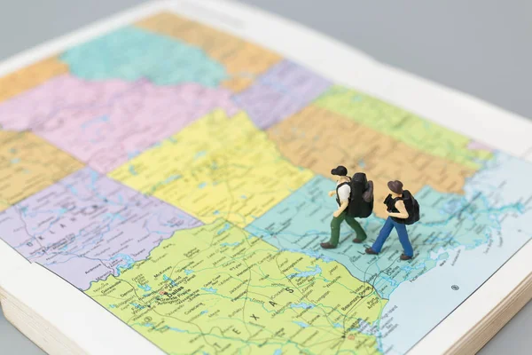 Miniature people Backpacker walking on map Travel and Adventure concepts.