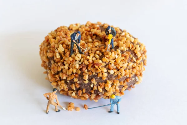 手作りチョコレートバターナッツドーナツを作るミニチュア作業チーム — ストック写真