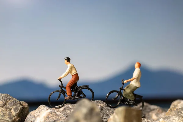 Miniature people : Traveler with bicycle riding on the rock , Travel and Adventure concepts.