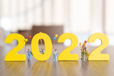 Minyatür insanlar Mutlu aile balonu 2022 numarada tutuyor Mutlu yıllar konsepti
