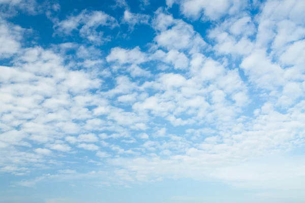 Blauwe lucht achtergrond met een witte wolken — Stockfoto