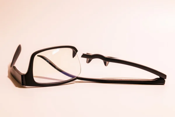 Closeup of Broken plastic Eyeglasses on colored background — Stock Photo, Image