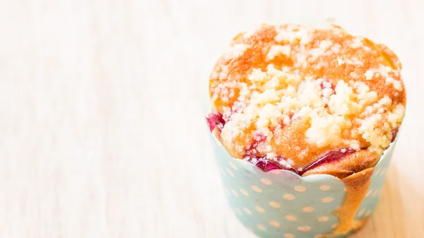 Muffiny jagodowe w papier ciastko na drewniane tła — Zdjęcie stockowe