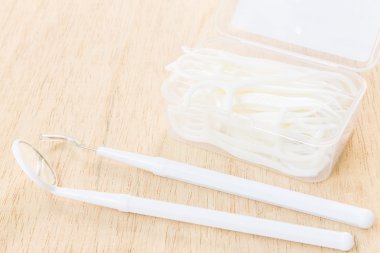 Sözlü aygıt: Ahşap arka plan üzerinde beyaz diş ipi bir kutu