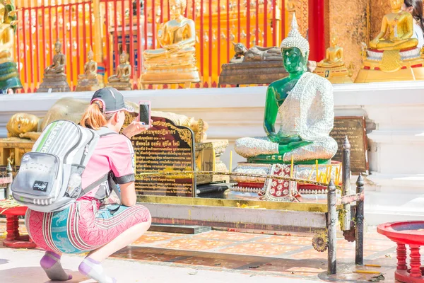 Kinesiska turist med en smartphone för att ta ett foto av en Buddha — Stockfoto